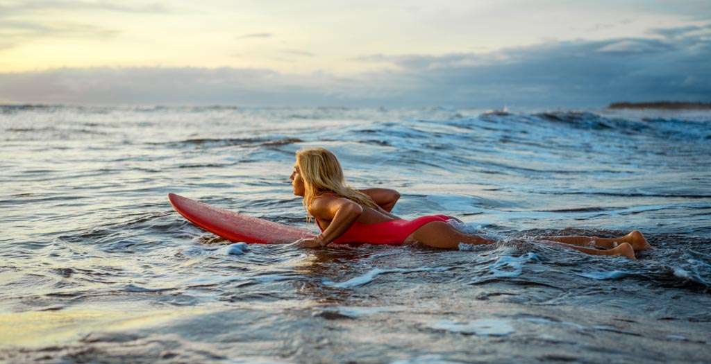 young-female-are-surfing-at-sunset